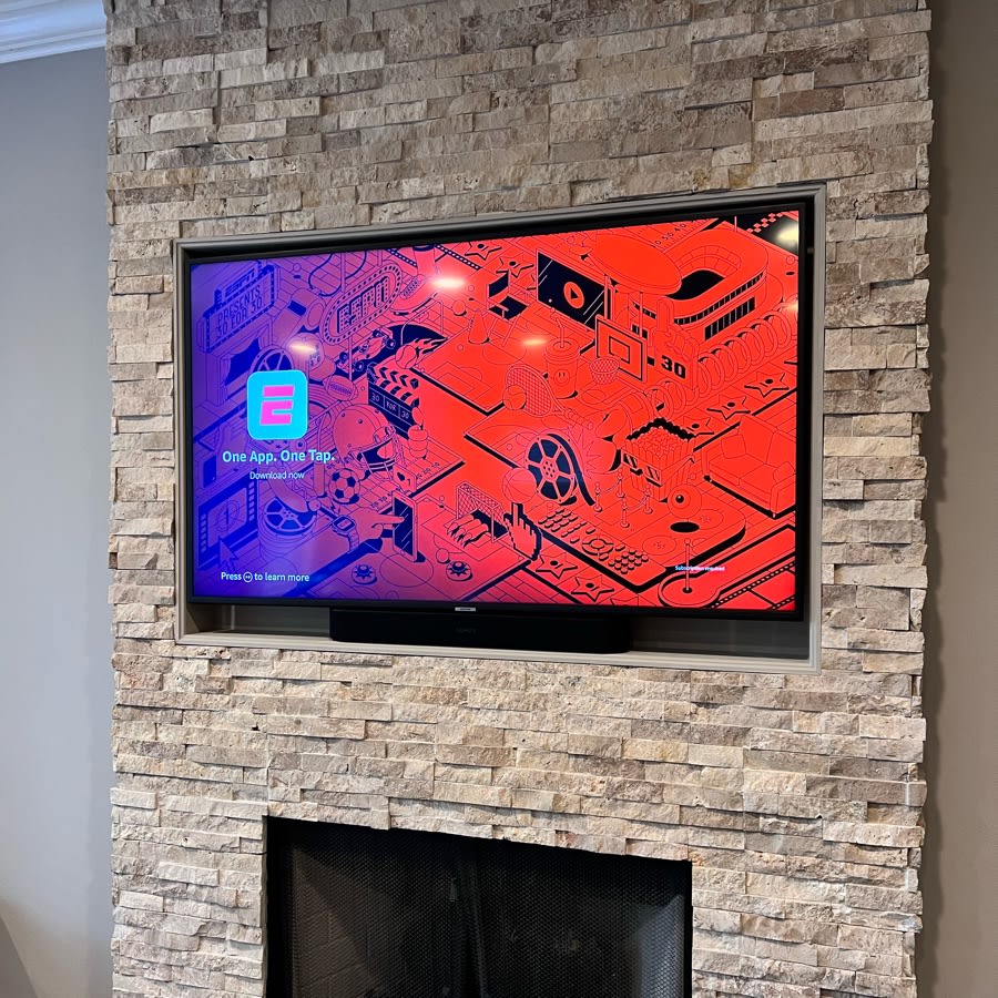 TV mounted in stone fireplace wall
